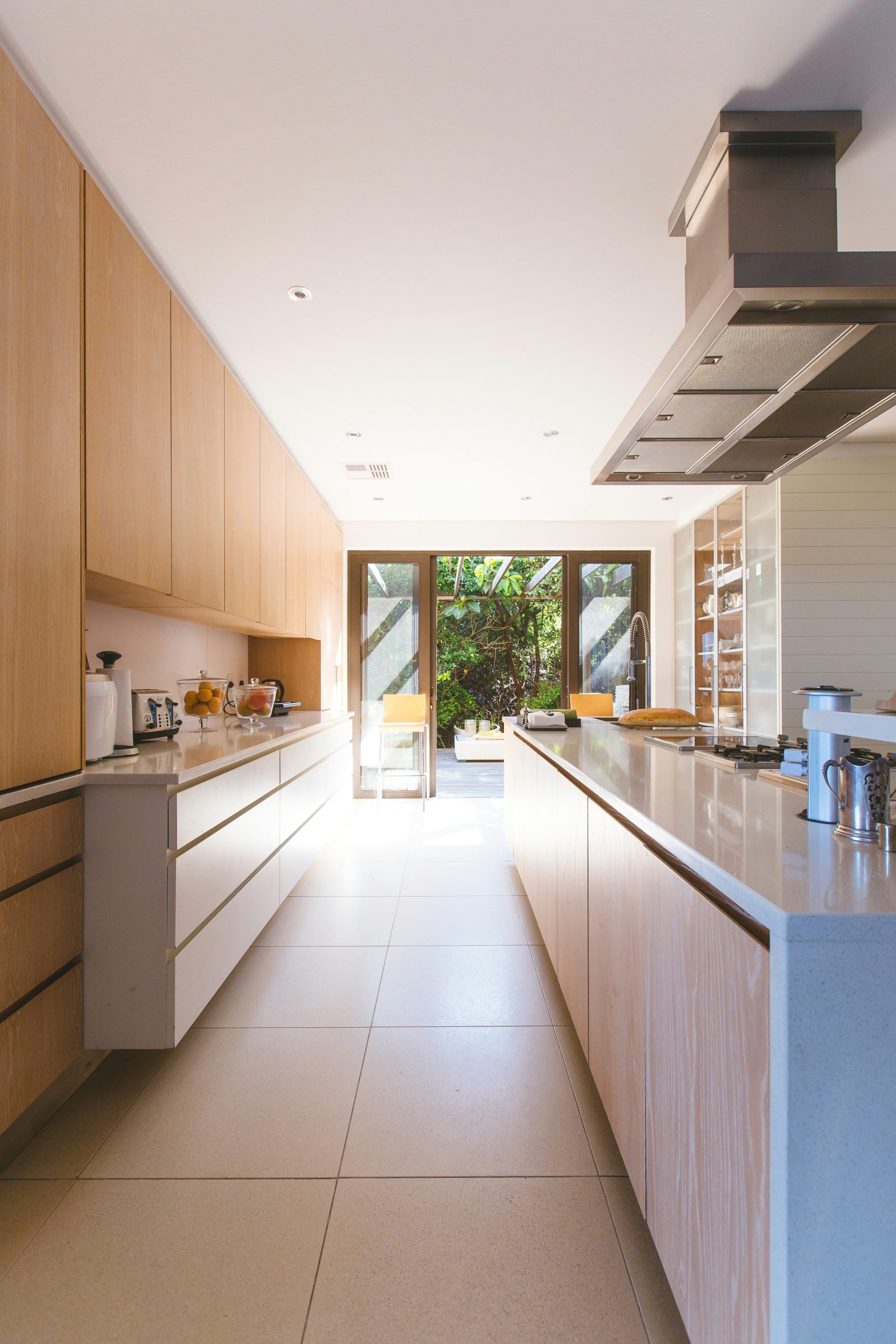 Isla de cocina de madera blanca y armarios empotrados cerca de la puerta con panel de vidrio.